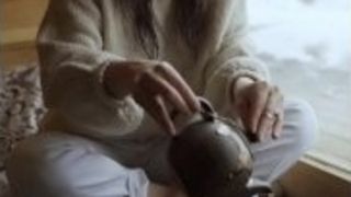 A doll cramming tea into a old school bowl