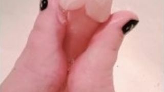 Greased up fake penis gets a filthy foot wank in the douche